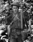 Tom Deas helping with a litter patient during the Battle of Colgan Woods, 7 May 1945